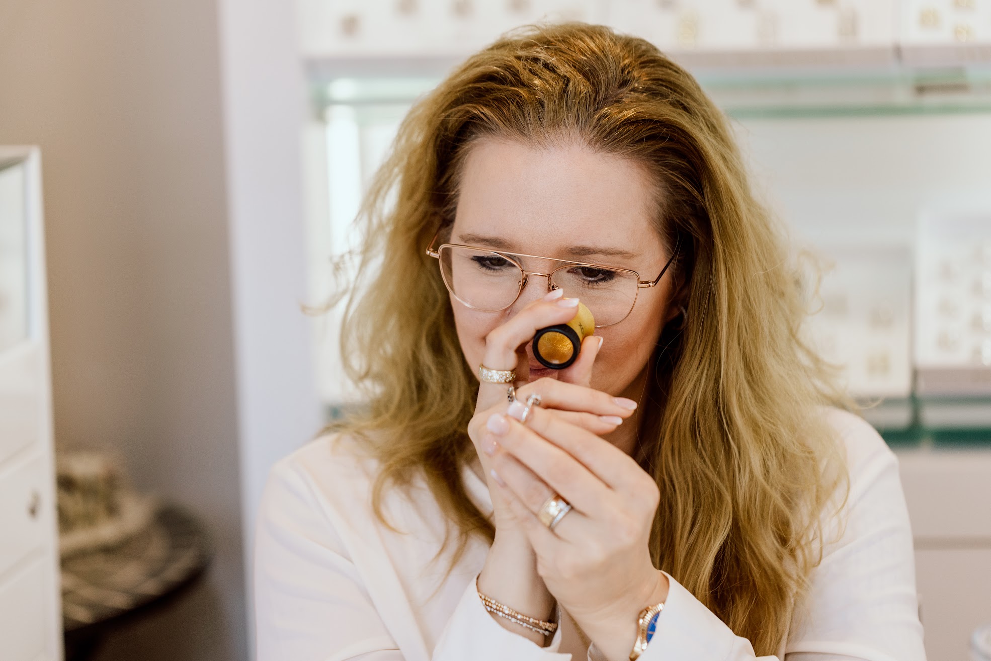 Myriam Luther-Brändle begutachtet einen Ring durch eine Diamantlupe.